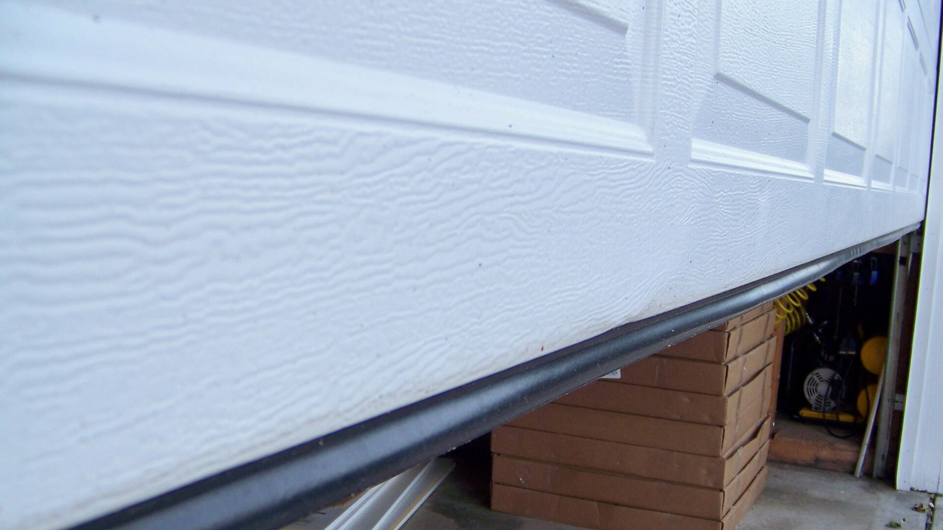 Securing bottom seals for garage door weatherproofing