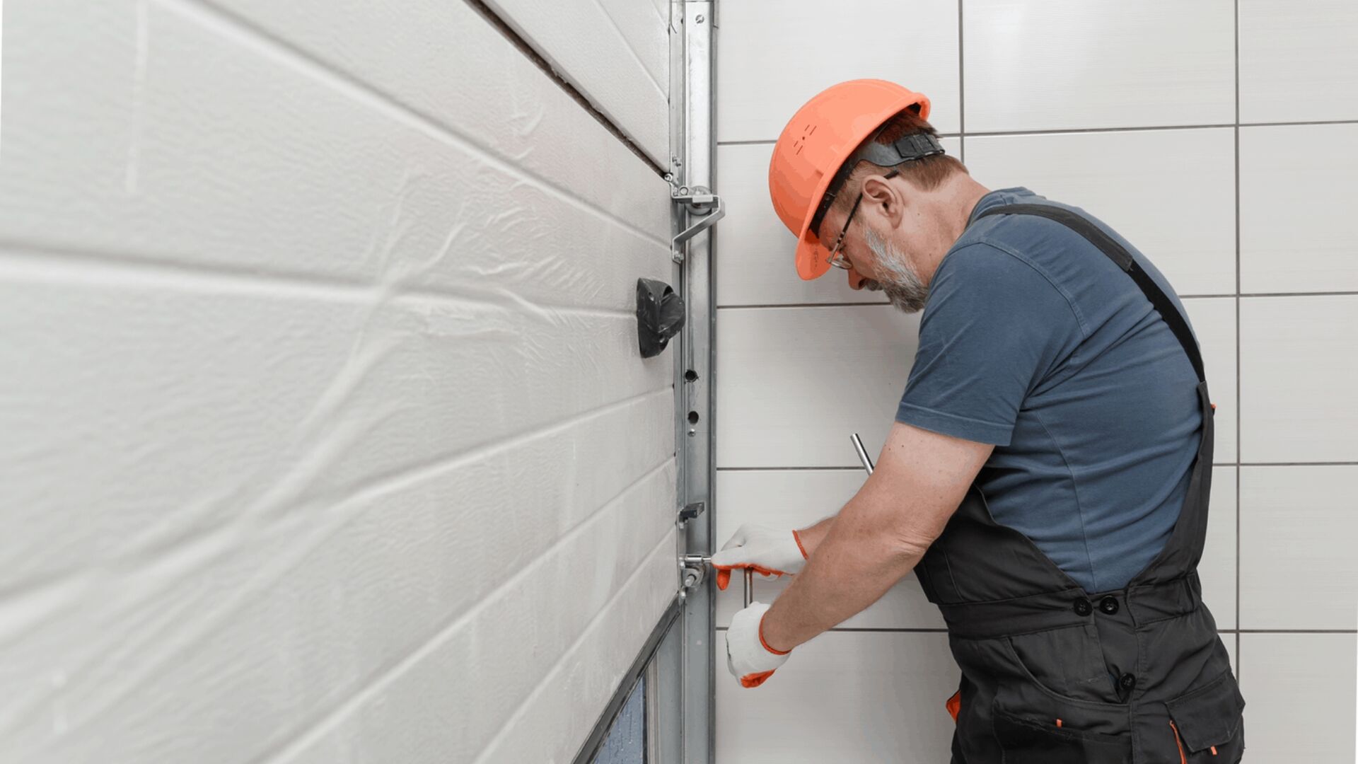A technician securing the hardware of a broken garage door.