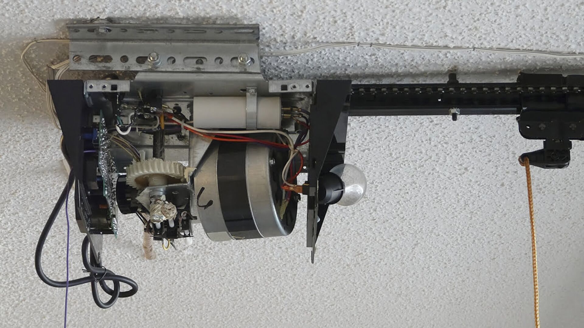 Close-up of a broken garage door motor mechanism.