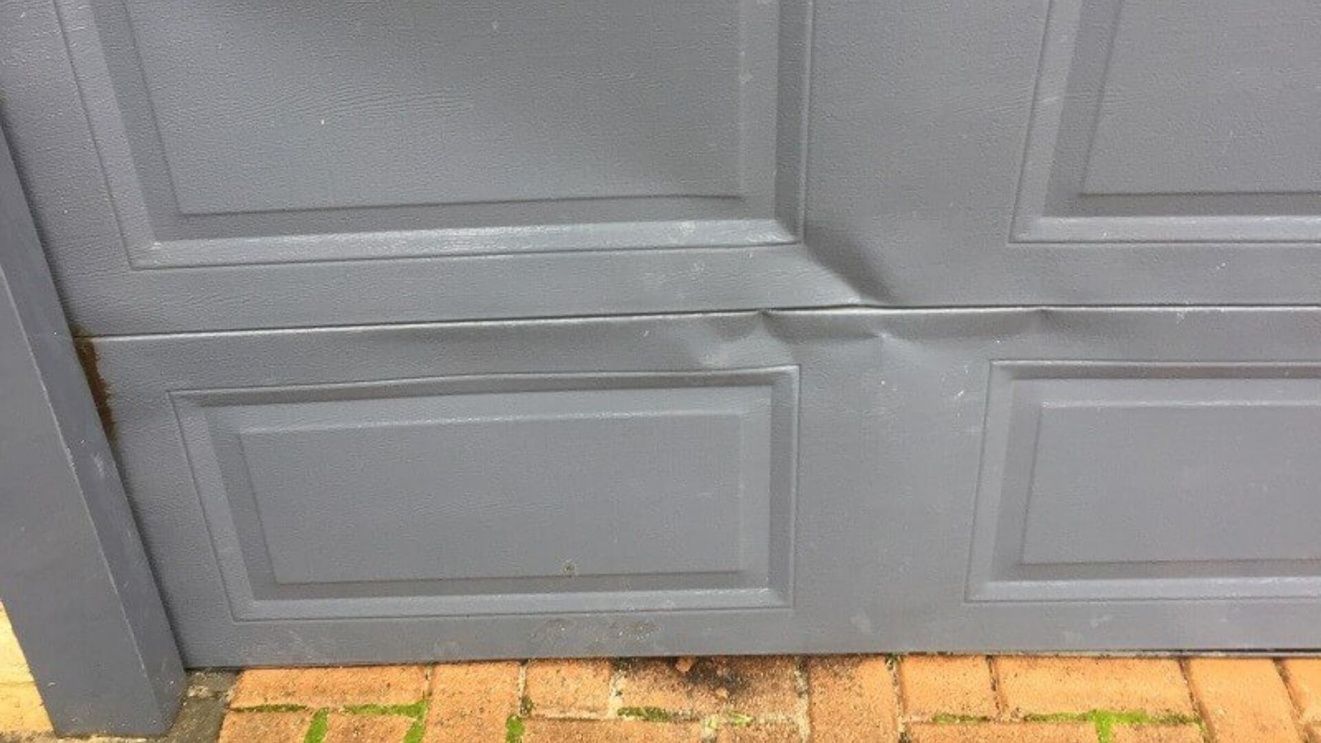 Damaged panels showing need for overhead door repair.