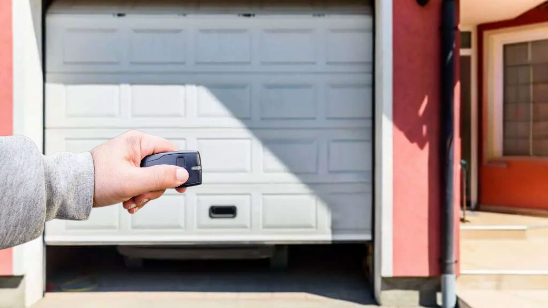 A woman pressing the garage door remote control to open their garage door