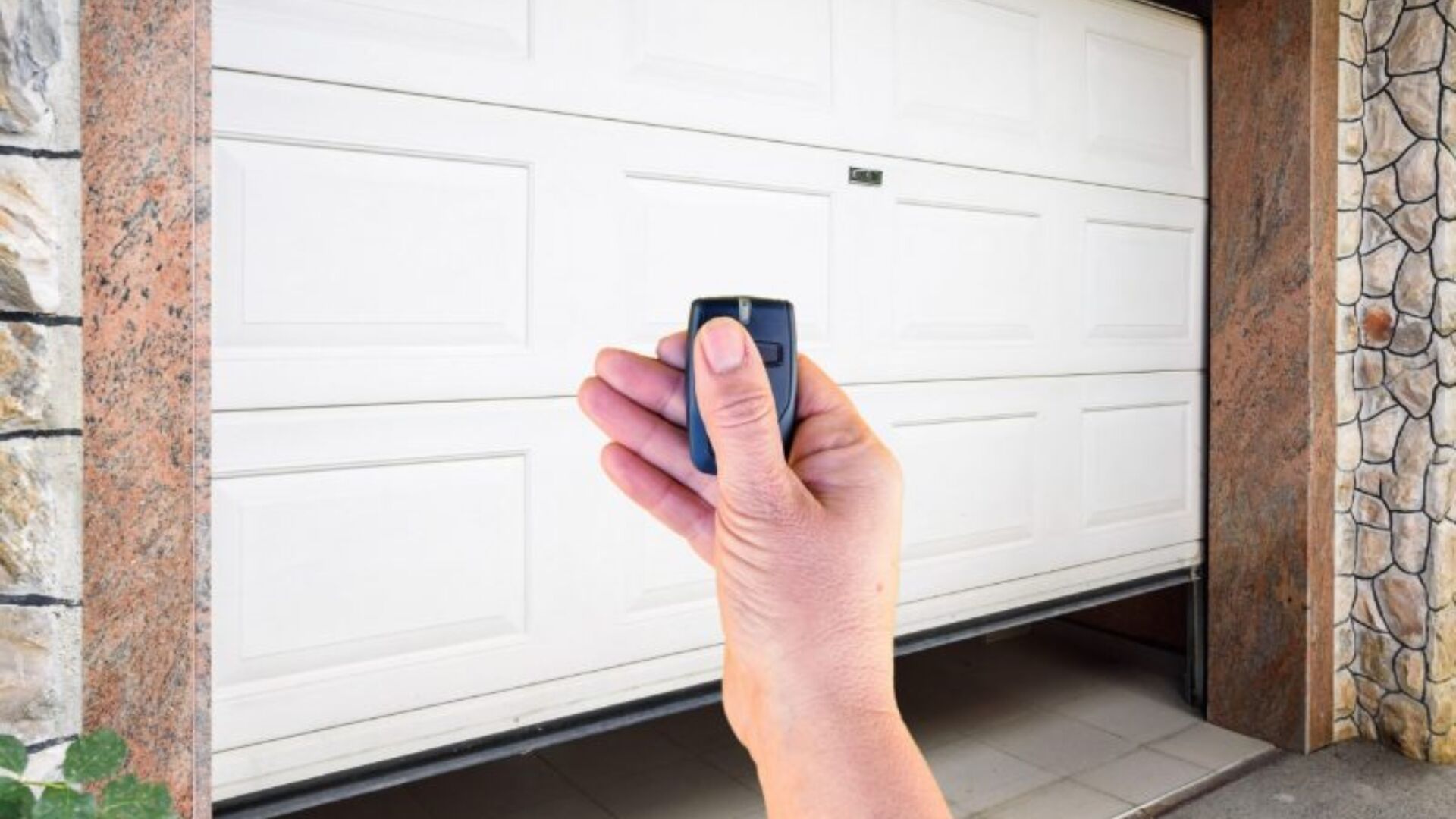 A homeowner checking if the garage door opener is working using the remote.